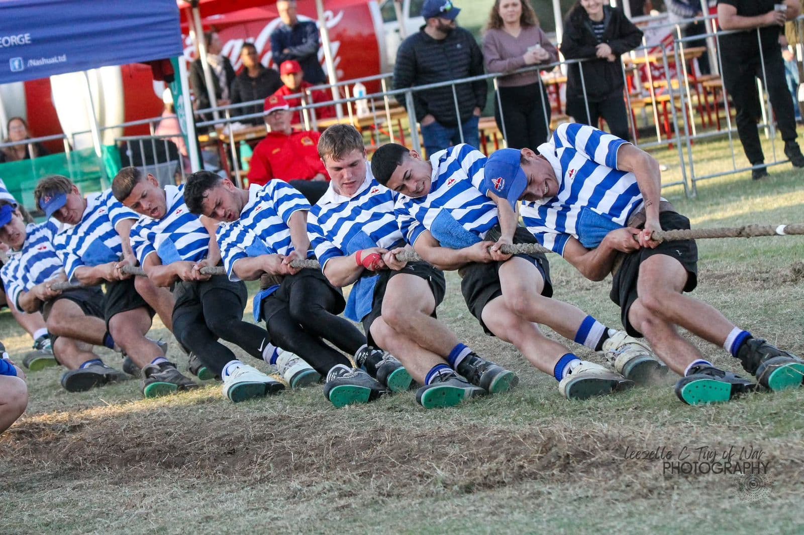 Tug-of-War team in striped uniforms competing at an event Tug-of-War team in striped uniforms competing at an event
