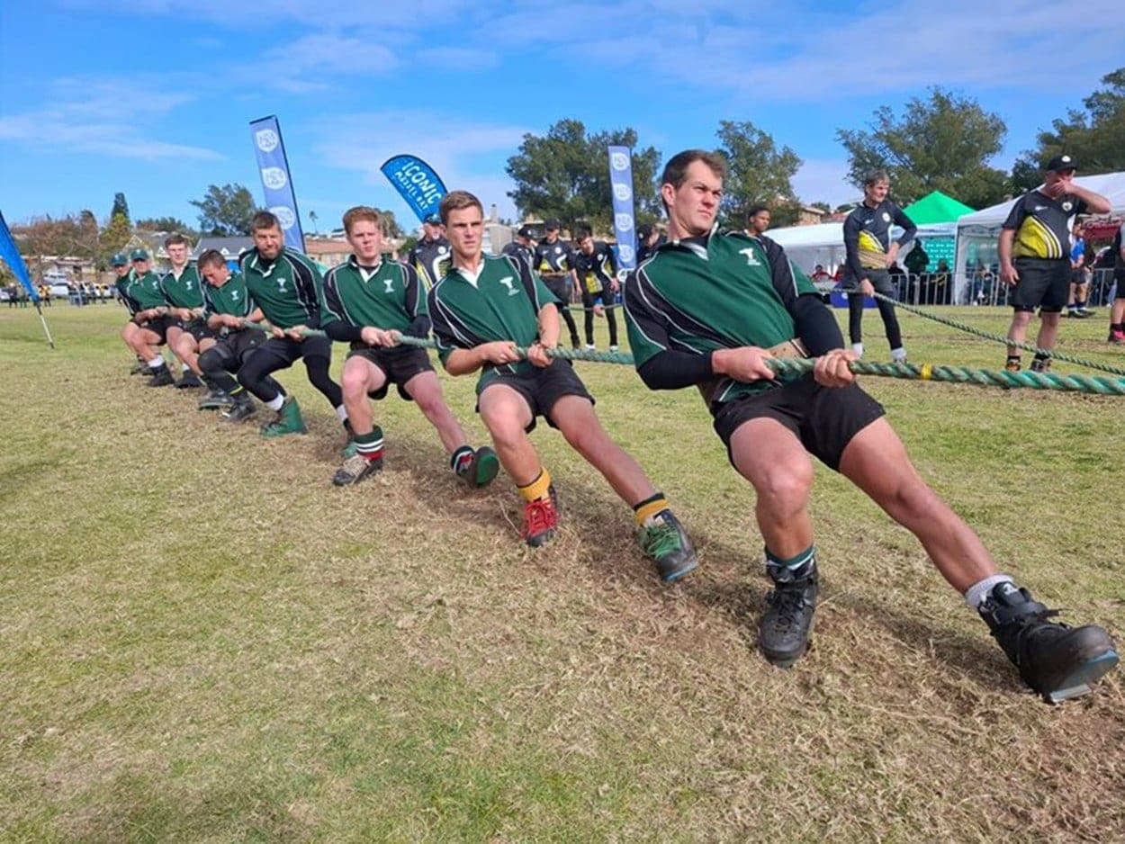 Tug-of-War team in green uniforms pulling during a tournament Tug-of-War team in green uniforms pulling during a tournament